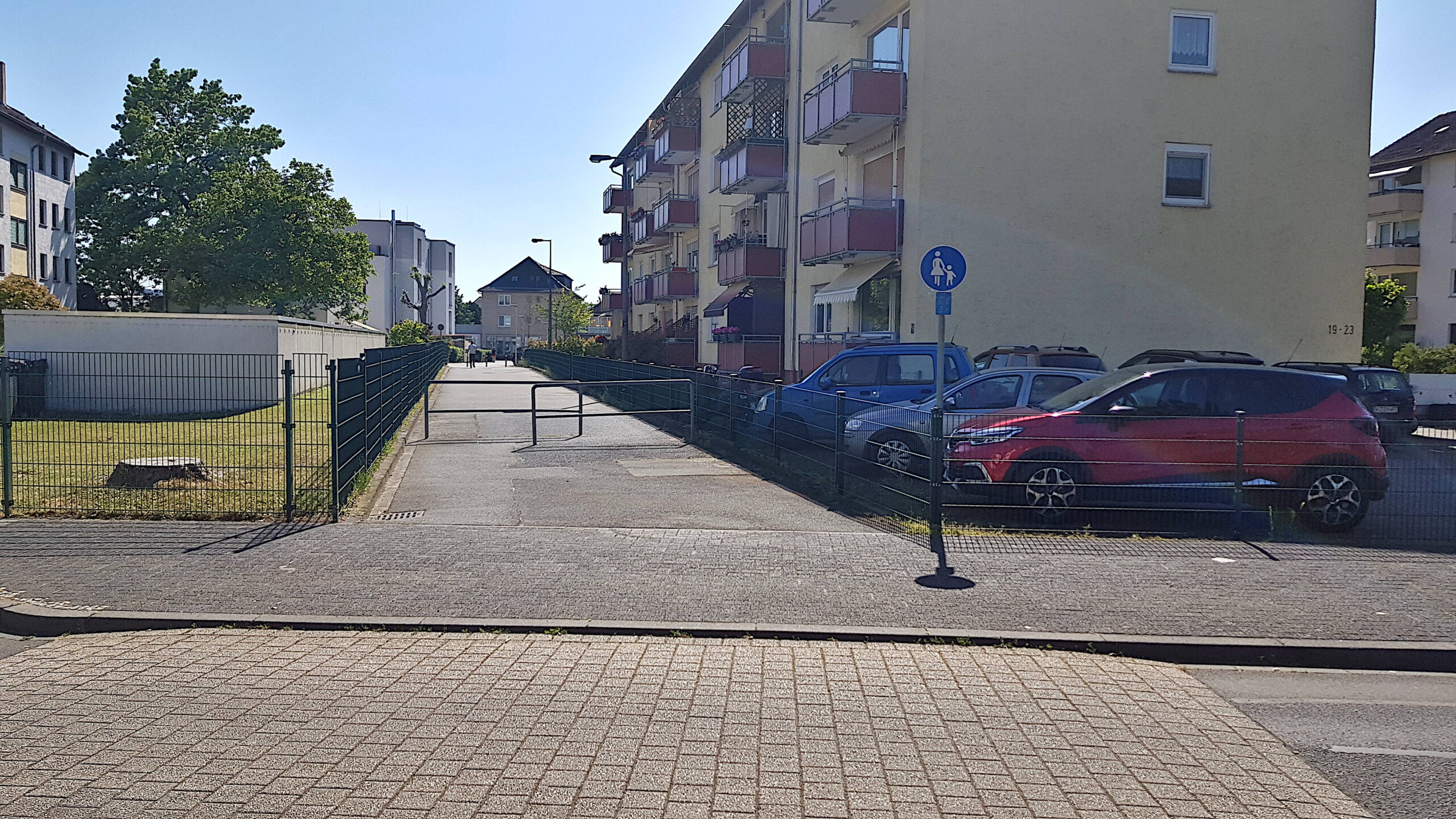 Abbildung 2: Blick von der Marie-Juchaz-Straße auf den Weg. Dieser ist derzeit als Gehweg ausgeschildert und mit zwei Umlaufgittern versehen.  Öffnung des Wegs zwischen Marie-Juchaz-Straße und Wiesbadener Straße für den Radverkehr